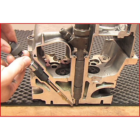 Querschnitt durch einen Motor. Eine Hand hält einen Injektor; daneben ein zweiter. Im Hintergrund das Innere des Motorblocks.